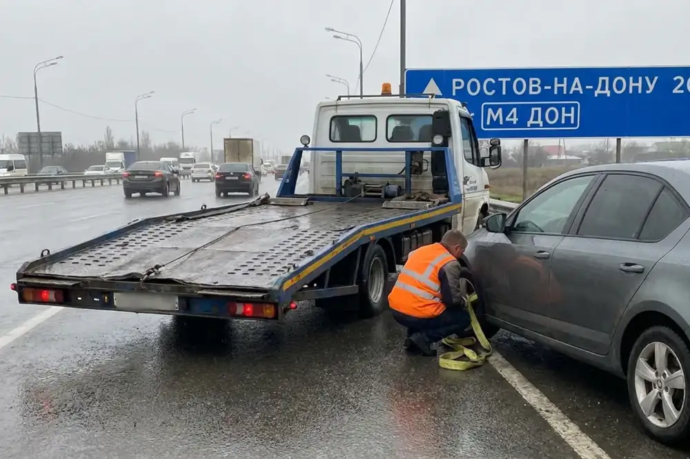Эвакуатор грузит легковой автомобиль на трассе М4